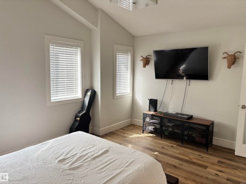 Room featuring wood-finish flooring, white walls, and two windows with white blinds - 11 James Crescent, St. Albert, AB - Indoor Photo Showing Bedroom