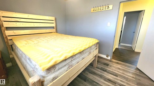 Wood-finish flooring extending from the room into a doorway - 12139 81 Street, Edmonton, AB - Indoor Photo Showing Bedroom