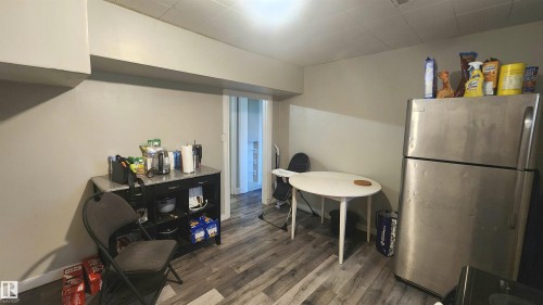 Kitchen area featuring wood-finish flooring and a stainless steel refrigerator - 12139 81 Street, Edmonton, AB - Indoor