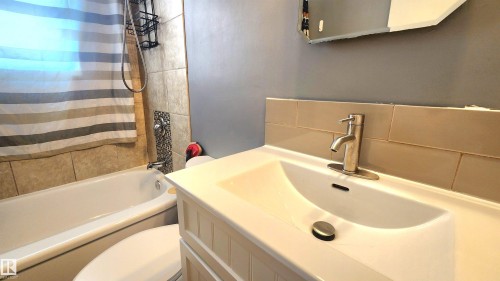 Bathroom featuring a white ceramic vanity sink, brushed nickel faucet, and a wall-mounted medicine cabinet - 12139 81 Street, Edmonton, AB - Indoor Photo Showing Bathroom