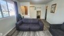 Living area with wood-finish flooring, white baseboards, and light-toned walls - 12139 81 Street, Edmonton, AB  - Indoor Photo Showing Living Room 