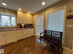 Kitchen area featuring extensive cabinetry, wood-finish flooring, a bay window over the sink, and recessed lighting - 