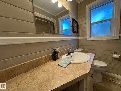 Vanity featuring a white basin sink with a chrome faucet, set into a stone-look countertop - 