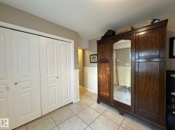 Light-toned square tile flooring throughout with white bi-fold closet doors featuring recessed panels - 
