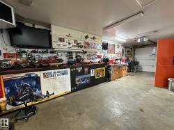Spacious utility area featuring extensive built-in cabinetry, integrated shelving, and fluorescent ceiling lighting - 