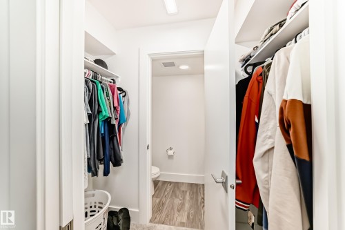 A well-organized closet space with built-in shelving and hanging rods - 307 9504 182 Street Nw, Edmonton, AB - Indoor With Storage