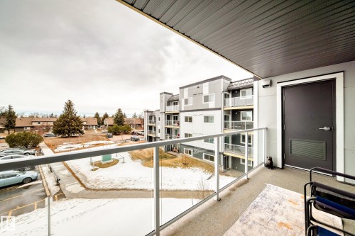 Balcony with glass railings and a textured ceiling - 307 9504 182 Street Nw, Edmonton, AB - Outdoor With Balcony With Exterior