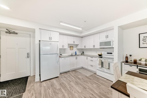 Bright kitchen with white cabinetry, granite countertops, and a white subway tile backsplash - 307 9504 182 Street Nw, Edmonton, AB - Indoor Photo Showing Kitchen