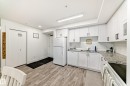 The kitchen features white cabinetry, granite countertops, a white subway tile backsplash, and a white refrigerator - 307 9504 182 Street Nw, Edmonton, AB  - Indoor Photo Showing Kitchen With Double Sink 