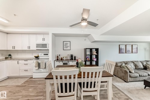 This property features a kitchen with white cabinetry, a microwave, and a white oven, complemented by light-colored countertops - 307 9504 182 Street Nw, Edmonton, AB - Indoor