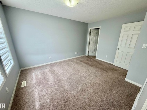 Neutral-toned carpeting paired with light blue-gray walls creates a serene atmosphere - 4310 Prowse Link Link, Edmonton, AB - Indoor Photo Showing Other Room
