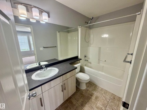 Modern bathroom featuring a vanity with a large mirror, dual sinks, and built-in cabinetry - 4310 Prowse Link Link, Edmonton, AB - Indoor Photo Showing Bathroom