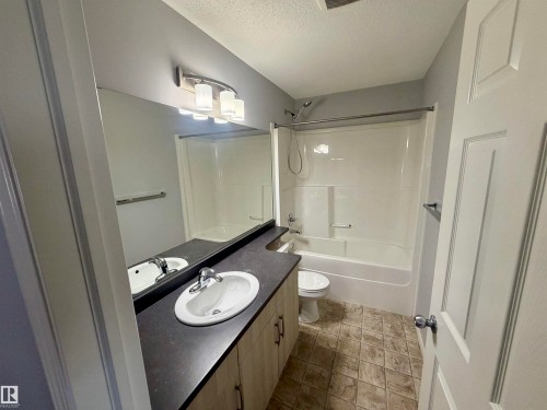 Bathroom featuring a vanity with a dark countertop, white oval sink, and a large mirror - 4310 Prowse Link Link, Edmonton, AB - Indoor Photo Showing Bathroom