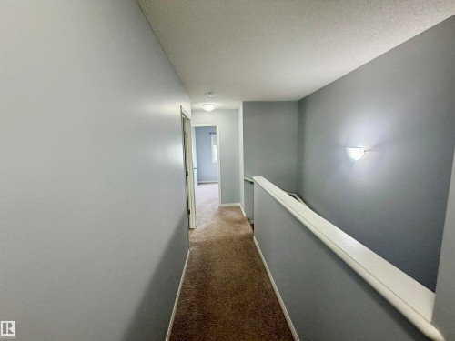 Upper-level hallway featuring neutral gray wall paint, textured carpet flooring, and a white ceiling - 4310 Prowse Link Link, Edmonton, AB - Indoor Photo Showing Other Room