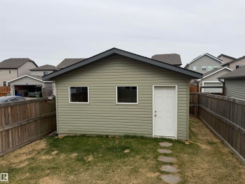 Detached auxiliary building featuring horizontal siding, two windows, and a panel door - 4310 Prowse Link Link, Edmonton, AB - Outdoor With Exterior