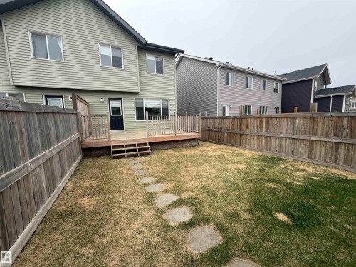 Expansive backyard featuring a natural wood fence and a green lawn - 4310 Prowse Link Link, Edmonton, AB - Outdoor With Exterior