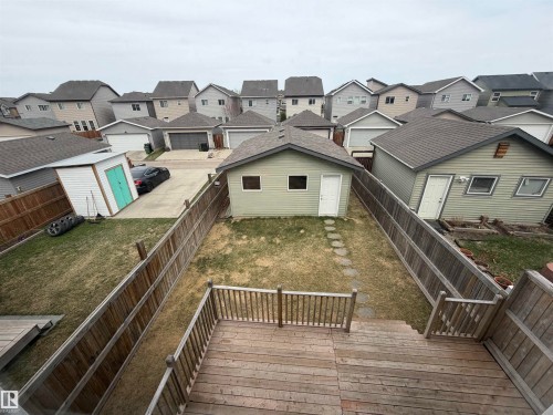 Rear yard featuring an elevated wood deck, wood fencing, and a detached structure with siding and a shingled roof - 4310 Prowse Link Link, Edmonton, AB - Outdoor