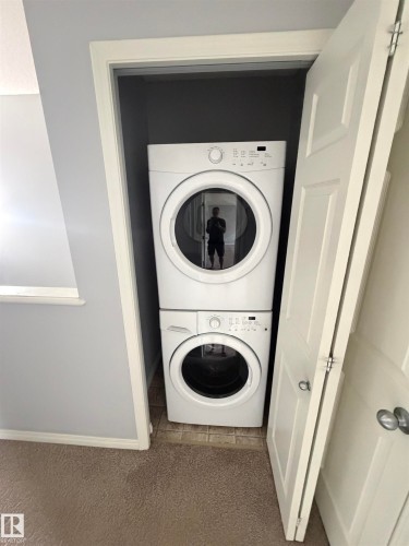 Dedicated laundry closet featuring a stacked washer and dryer unit - 4310 Prowse Link Link, Edmonton, AB - Indoor Photo Showing Laundry Room