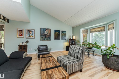 Spacious interior featuring wood-finish flooring, light blue walls, and a vaulted planked ceiling - 1235 104 Street, Edmonton, AB - Indoor Photo Showing Living Room