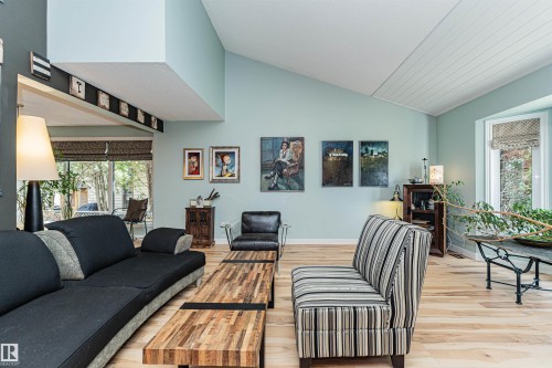 Light wood-finish flooring complements vaulted ceilings and a paneled accent ceiling - 1235 104 Street, Edmonton, AB - Indoor Photo Showing Living Room