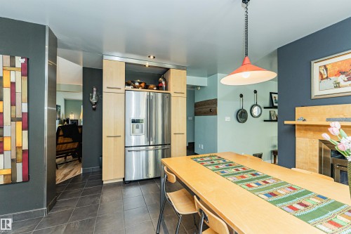 Stainless steel French door refrigerator integrated into light wood cabinetry - 1235 104 Street, Edmonton, AB - Indoor