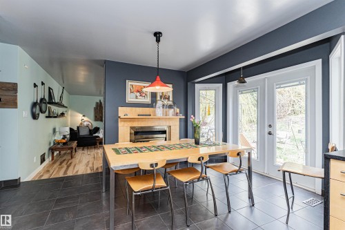 Dining area with dark tile flooring and a light wood-finish dining table - 1235 104 Street, Edmonton, AB - Indoor Photo Showing Dining Room