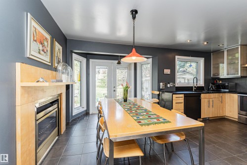 Open-concept dining and kitchen area with dark tile flooring - 1235 104 Street, Edmonton, AB - Indoor With Fireplace