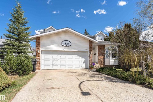 Split-level residence featuring a two-car garage, white siding, and brick accents - 1235 104 Street, Edmonton, AB - Outdoor