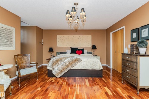 Rich wood-finish flooring complements the neutral wall tones - 1235 104 Street, Edmonton, AB - Indoor Photo Showing Bedroom
