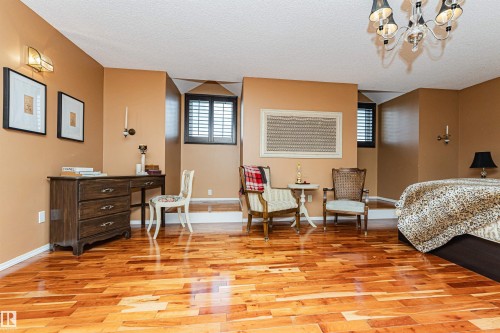 Hardwood flooring throughout, featuring warm-toned walls, and recessed windows with dark louvered shutters - 1235 104 Street, Edmonton, AB - Indoor