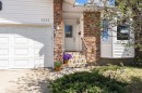 Brick and siding exterior featuring a white garage door, front entry with transom window, and a bay window - 1235 104 Street, Edmonton, AB  - Outdoor 