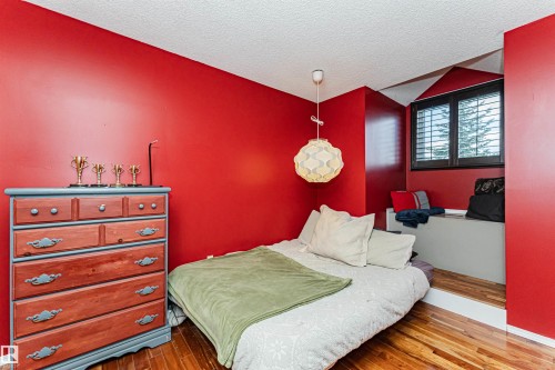Bedroom featuring rich red walls and wood-finish flooring - 1235 104 Street, Edmonton, AB - Indoor Photo Showing Bedroom