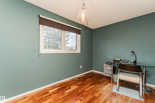 Hardwood flooring extending throughout, window with roller shade, pendant light fixture, and painted walls - 1235 104 Street, Edmonton, AB - Indoor