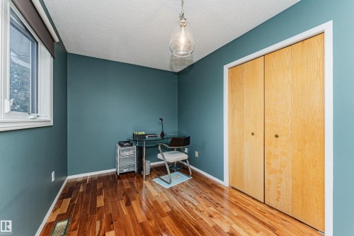 Room featuring rich wood-finish flooring and a contemporary pendant light fixture - 1235 104 Street, Edmonton, AB - Indoor Photo Showing Other Room