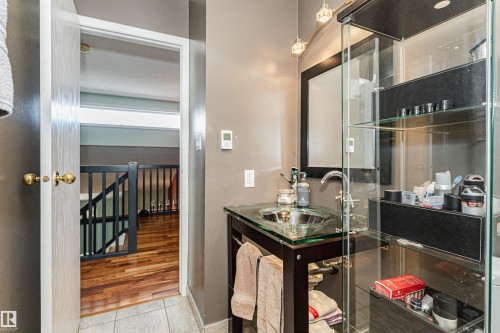 Bathroom featuring a glass vessel sink, chrome faucet, and integrated glass shelving - 1235 104 Street, Edmonton, AB - Indoor