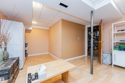 Finished room featuring wood-finish flooring, drop ceiling with recessed lighting, and a neutral wall color - 1235 104 Street, Edmonton, AB - Indoor