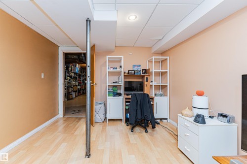 Room featuring wood-finish flooring, drop ceiling panels, recessed lighting, and a neutral wall color - 1235 104 Street, Edmonton, AB - Indoor