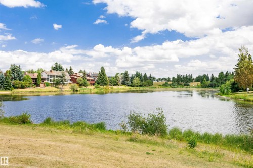 Natural lake setting with surrounding properties, lush trees, and a clear sky - 1235 104 Street, Edmonton, AB - Outdoor With Body Of Water With View