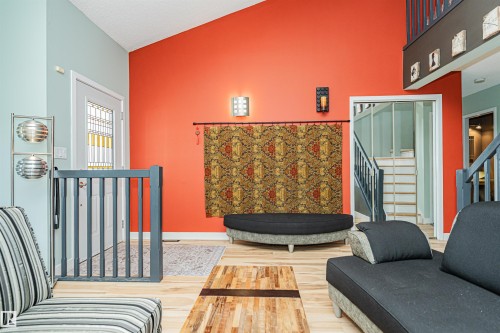 Vaulted ceiling with an architectural accent wall and wood-finish flooring - 1235 104 Street, Edmonton, AB -  Photo Showing Other Room