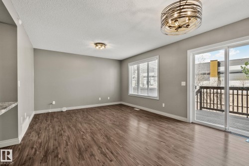 Open-concept room featuring wood-finish flooring, neutral gray walls, and white trim - 46 445 Brintnell Boulevard, Edmonton, AB - Indoor Photo Showing Other Room