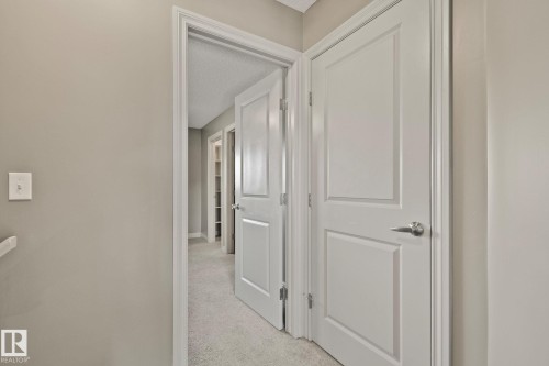 Interior hallway featuring neutral-toned walls, white trim, and light gray carpet - 46 445 Brintnell Boulevard, Edmonton, AB - Indoor Photo Showing Other Room