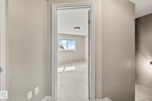 Carpeted interior room with neutral-toned walls, a window, and a flush-mount ceiling light fixture - 46 445 Brintnell Boulevard, Edmonton, AB - Indoor Photo Showing Other Room