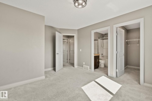 Carpeted bedroom with neutral wall tones, a semi-flush mount ceiling light, and white trim - 46 445 Brintnell Boulevard, Edmonton, AB - Indoor Photo Showing Other Room