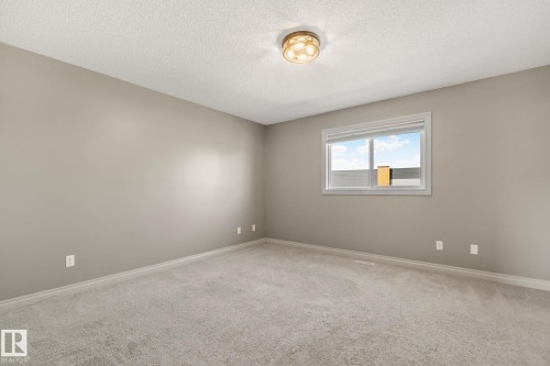 Spacious room featuring neutral carpeting, light-toned wall paint, and white trim - 46 445 Brintnell Boulevard, Edmonton, AB - Indoor Photo Showing Other Room