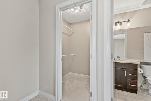 Walk-in closet featuring light gray carpeting and white shelving - 46 445 Brintnell Boulevard, Edmonton, AB - Indoor