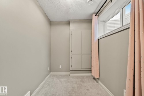 Carpeted room with a built-in storage cabinet and a window - 46 445 Brintnell Boulevard, Edmonton, AB - Indoor Photo Showing Other Room