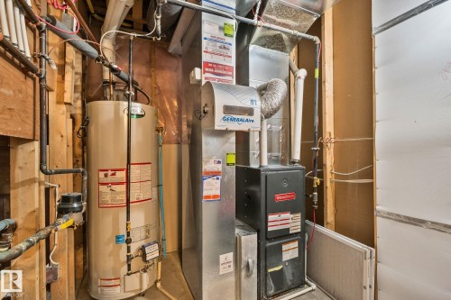 Utility area featuring a water heater and furnace with exposed wood framing - 46 445 Brintnell Boulevard, Edmonton, AB - Indoor Photo Showing Basement
