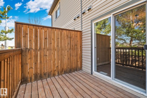Outdoor deck area featuring wood-finish decking and a coordinating wood privacy fence - 46 445 Brintnell Boulevard, Edmonton, AB - Outdoor With Deck Patio Veranda With Exterior