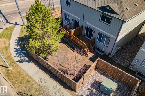 Rear exterior of a residence featuring light gray siding and a dark shingle roof - 46 445 Brintnell Boulevard, Edmonton, AB - Outdoor