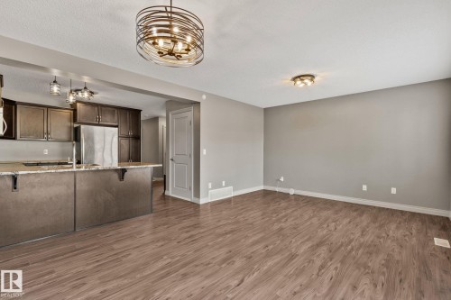 Open-concept living area featuring wood-finish flooring, a contemporary chandelier, and recessed lighting - 46 445 Brintnell Boulevard, Edmonton, AB - Indoor Photo Showing Kitchen